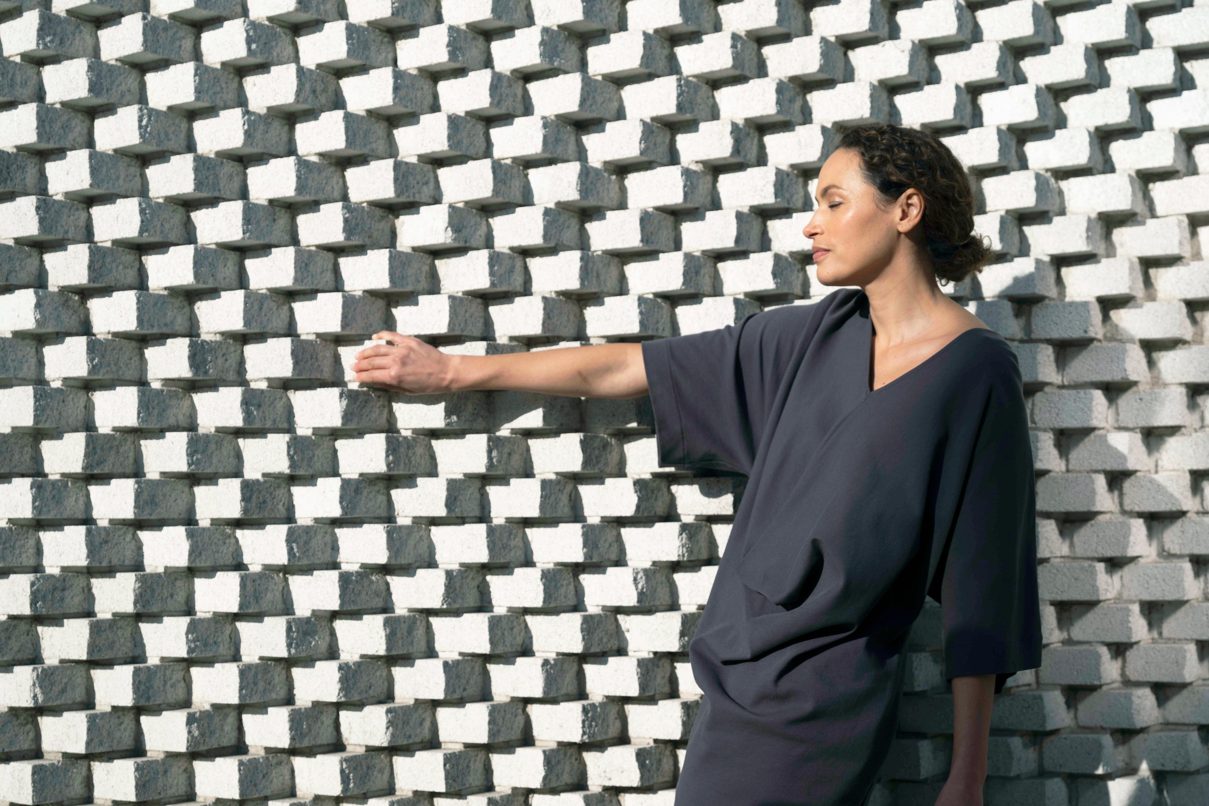 Woman standing against a geometric patterned wall